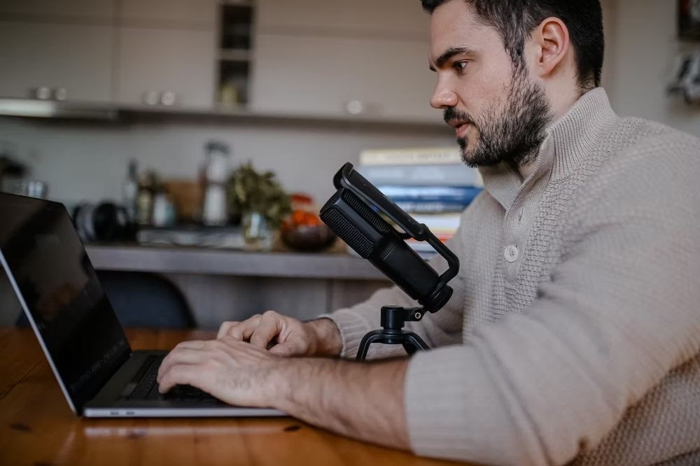 man on laptop podcasting