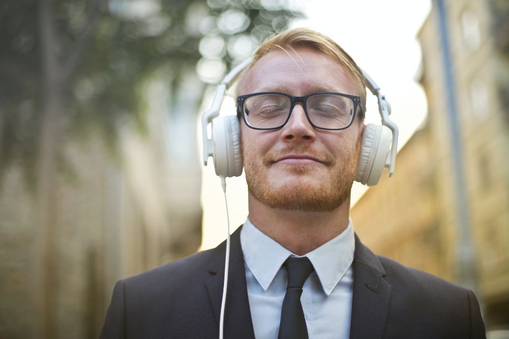 man with headphones listening to a good podcast because he first read its show notes