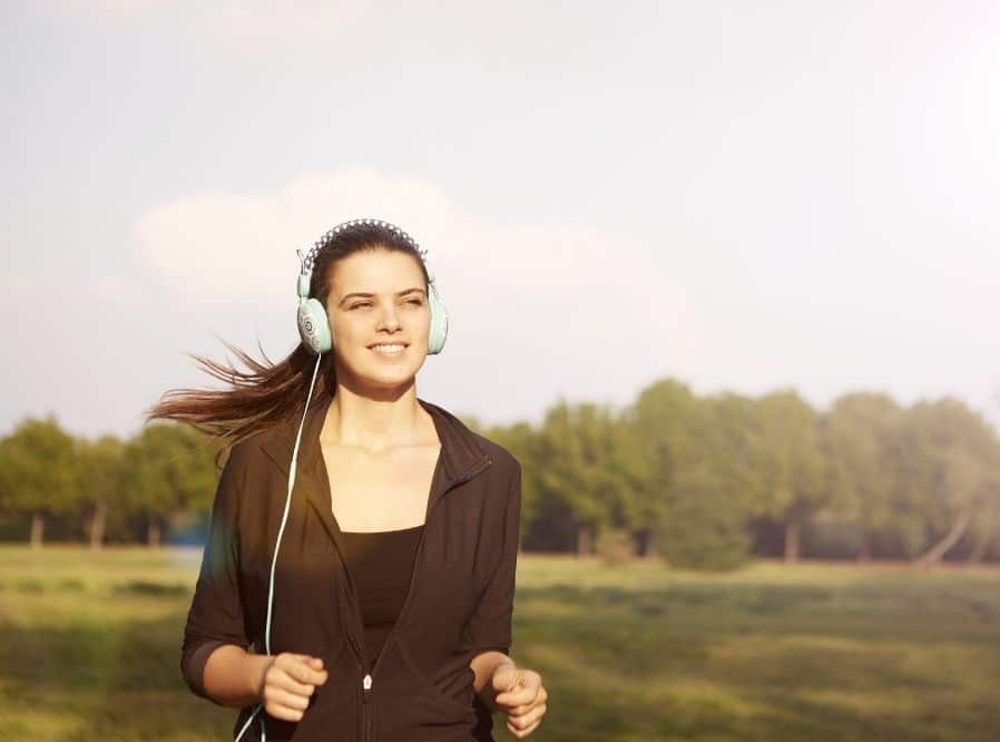 woman enjoying her podcast while on a run