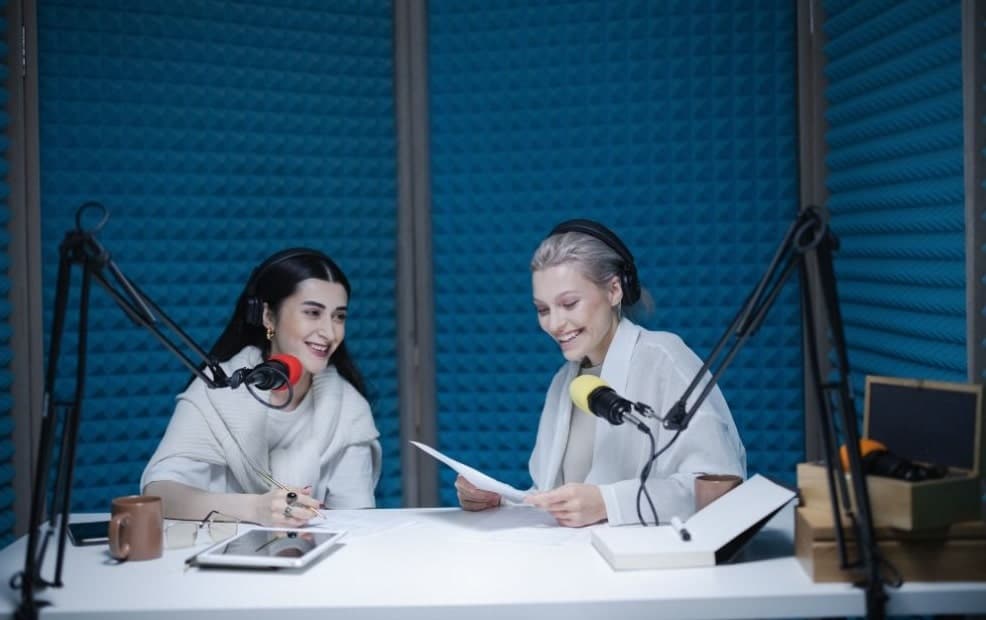 two women conversing on-air for a podcast series