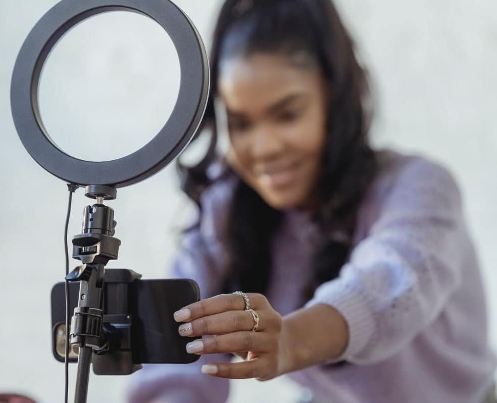 A woman recording herself to promote her podcast on various marketing channels