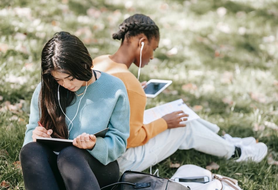 two female students learning more about their coursework through a podcast