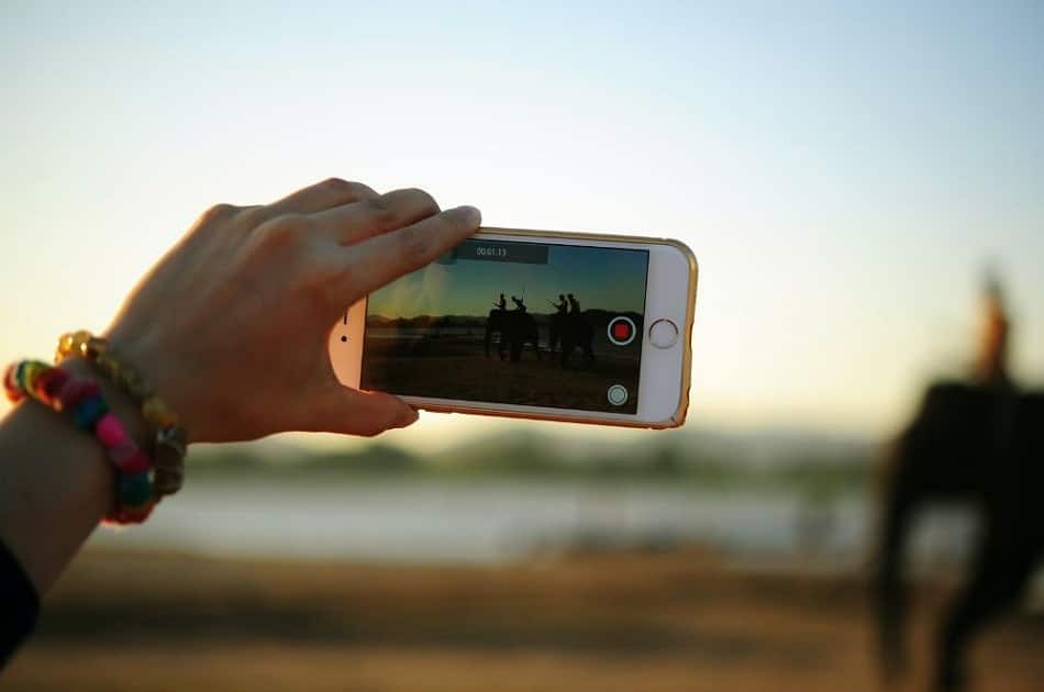 a woman recording a video on her phone with sound effects to be added during the editing process